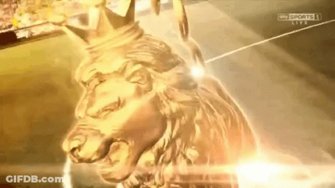 A Gold Statue Of A Lion With A Crown On It GIF