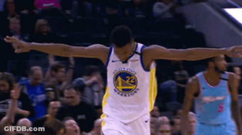 A Golden State Warriors Basketball Player Celebrates With His Arms Outstretched In Front Of A Crowd GIF