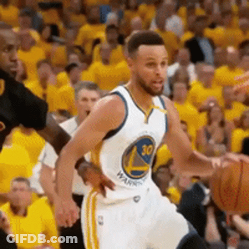 A Golden State Warriors Player Is Dribbling A Basketball In Front Of A Crowd GIF