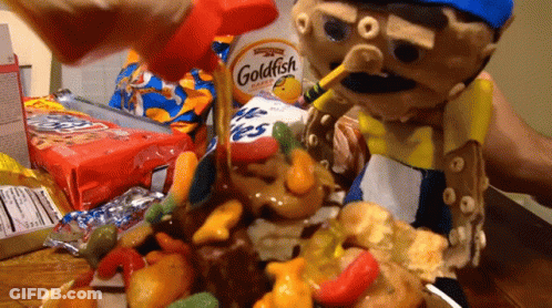 A Goldfish Cracker Is Being Poured Over A Pile Of Candy GIF