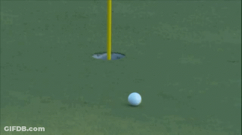 A Golf Ball Is Going Into A Hole On A Golf Course GIF
