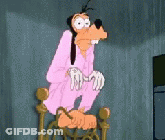 A Goofy Cartoon Character Is Sitting On A Chair With His Hands On His Knees . GIF