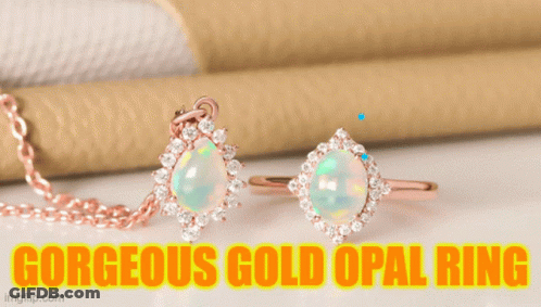 A Gorgeous Gold Opal Ring Sits On A Green Stem GIF
