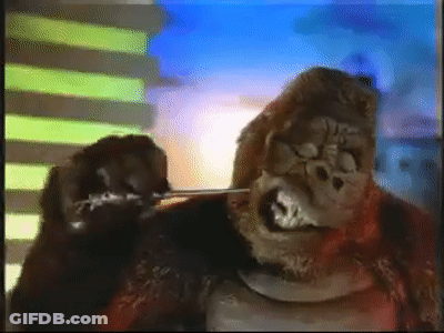 A Gorilla Is Standing In Front Of A Building . GIF
