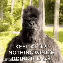 A Gorilla Is Standing In The Woods With The Words `` Keep At It ! Nothing Worth Doing Is Easy . '' . GIF