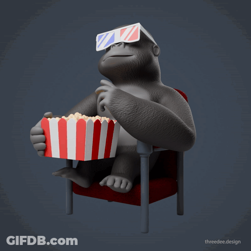 A Gorilla Wearing 3D Glasses Is Sitting In A Red Chair Eating Popcorn GIF