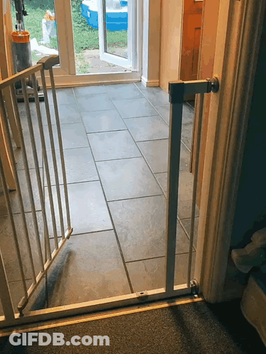 A Gray Tile Floor With A White Gate Between The Door And The Floor GIF