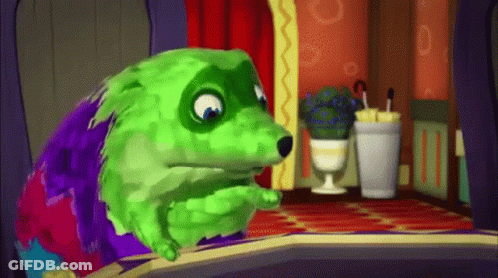 A Green And Purple Cartoon Dog Is Sitting In A Room . GIF