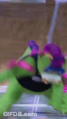 A Green And Purple Turtle Is Playing A Game Of Basketball GIF