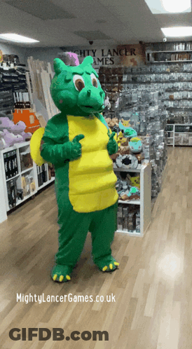 A Green And Yellow Dragon Mascot Giving A Thumbs Up In Front Of A Sign For Mighty Lancer Games GIF