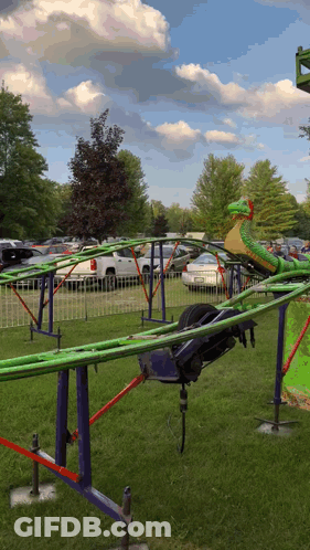 A Green And Yellow Roller Coaster With A Snake In The Middle GIF