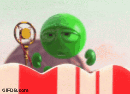 A Green Ball With A Sad Face Is Holding A Microphone In Front Of A Striped Popcorn Box GIF