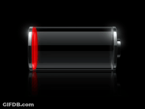 A Green Battery Is Glowing In The Dark On A Black Surface GIF