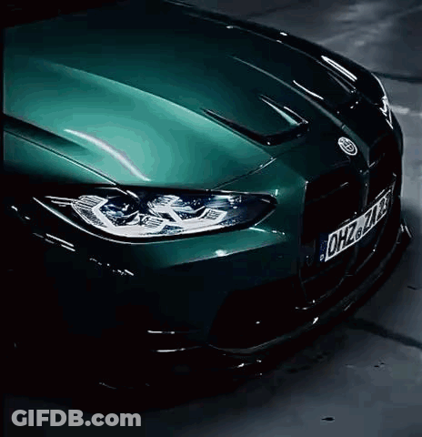 A Green Bmw M3 Is Driving Down A Parking Garage . GIF