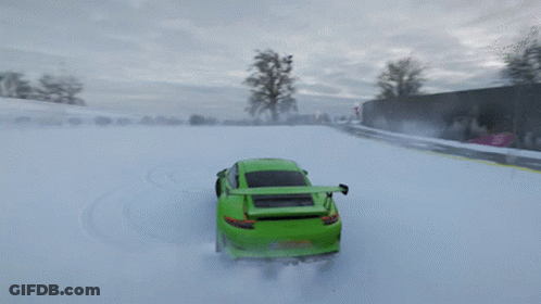 A Green Car Is Driving Through The Snow On A Road GIF