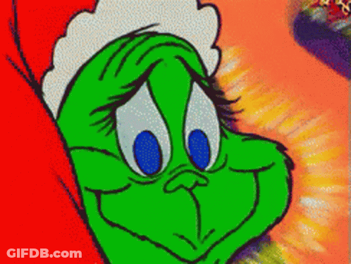 A Green Cartoon Character With Blue Eyes And A Santa Hat On GIF