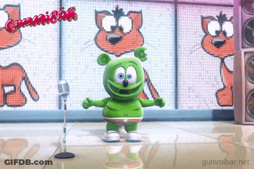 A Green Gummy Bear Is Dancing In Front Of A Microphone With The Words Gummibar Written On The Screen Behind Him GIF