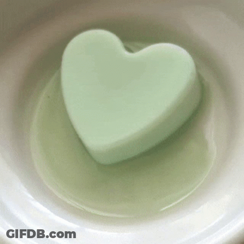 A Green Heart Shaped Soap Is In A White Bowl GIF