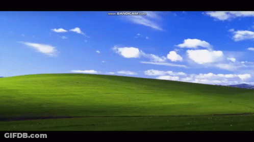 A Green Hill With A Blue Sky And White Clouds Is Displayed On A Computer Screen GIF