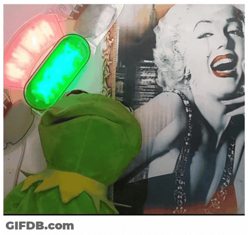 A Green Kermit Frog Is Standing In Front Of A Picture Of Marilyn Monroe GIF