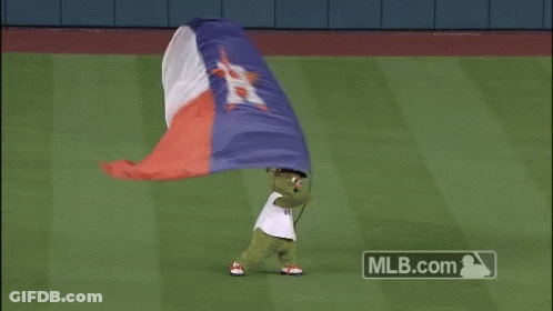 A Green Mascot Is Holding A Texas Flag GIF
