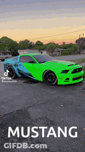 A Green Mustang Is Parked In A Parking Lot At Sunset GIF