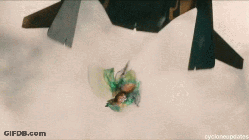 A Green Object Is Floating In The Air With A Jet Flying In The Background . GIF