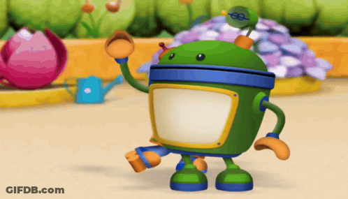 A Green Robot Is Standing In Front Of A Flower Bed GIF