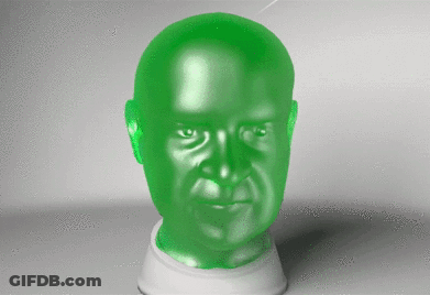 A Green Statue Of A Man 'S Head Is Sitting On A White Base GIF