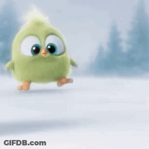 A Green Stuffed Animal With Big Eyes Is Walking In The Snow . GIF