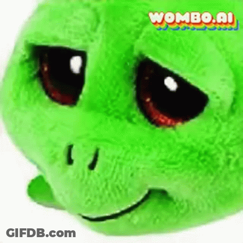 A Green Stuffed Turtle With A Sad Look On Its Face Is Sitting On A White Surface . GIF