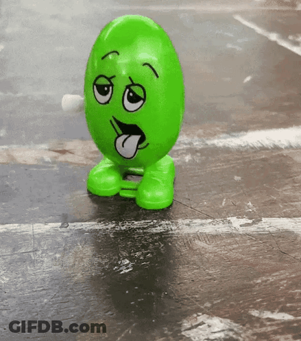 A Green Toy With A Face On It Sticking Out Its Tongue GIF