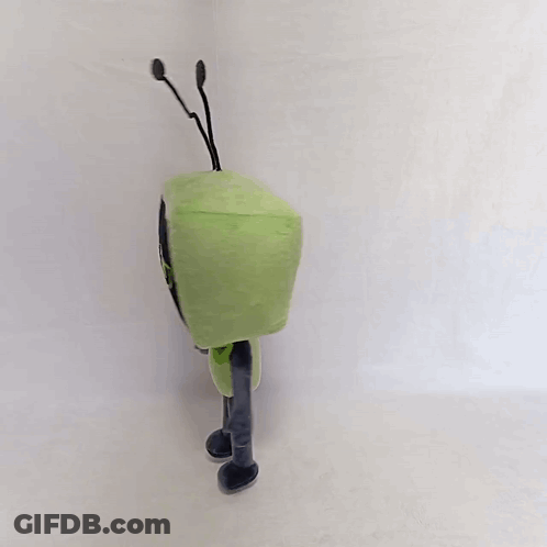 A Green Toy With Antennas On Its Head Is Standing On A White Surface GIF