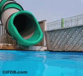 A Green Water Slide Is Going Down A Pool GIF
