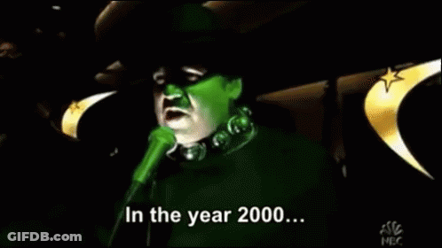 A Green Witch Singing Into A Microphone With The Words In The Year 2000 GIF