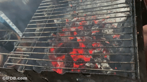 A Grill With A Lot Of Coals On It And Smoke Coming Out Of It GIF
