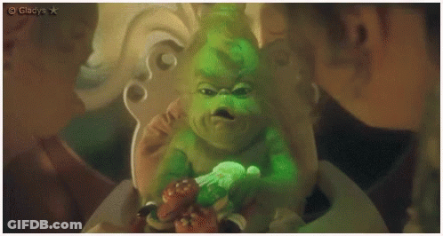 A Grinch Is Sitting In A Chair And Looking At The Camera With A Caption That Says Gladys GIF