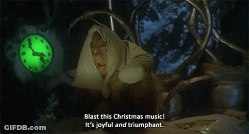 A Grinch Says Blast This Christmas Music It 'S Joyful And Triumphant In Front Of A Clock GIF