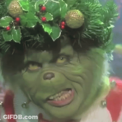 A Grinch Wearing A Christmas Wreath On His Head GIF
