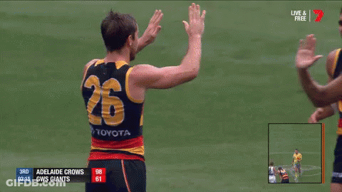 A Group Of Adelaide Crows Players Are Celebrating A Goal GIF