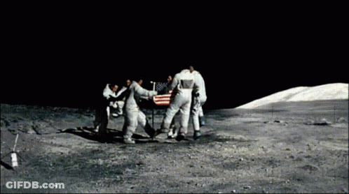 A Group Of Astronauts Are Standing Around An American Flag On The Moon GIF