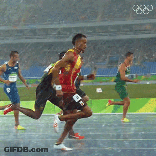 A Group Of Athletes Are Running On A Track With The Olympic Rings Visible In The Background GIF