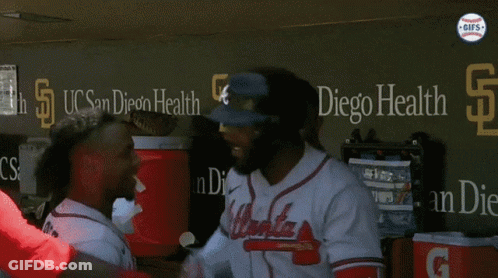 A Group Of Atlanta Braves Baseball Players Stand In A Dugout GIF