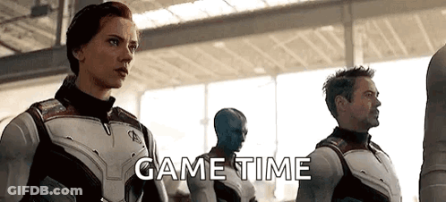 A Group Of Avengers Standing Next To Each Other In A Room With The Words `` Game Time '' Written On The Bottom . GIF