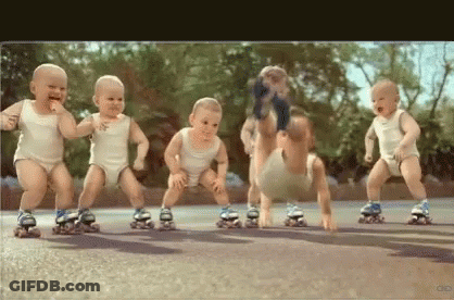 A Group Of Babies Are Rollerblading On A Road . GIF