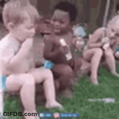 A Group Of Babies Are Sitting On The Grass Eating Ice Cream . GIF