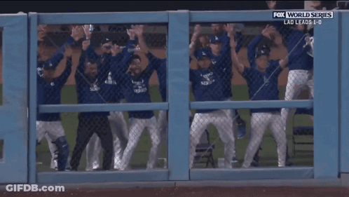 A Group Of Baseball Players Are Behind A Fence With Fox World Series Written Above Them GIF