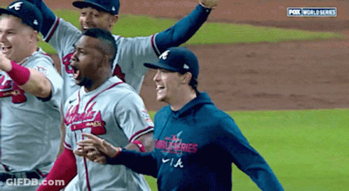 A Group Of Baseball Players Are Celebrating On A Field With Fox World Series In The Background GIF