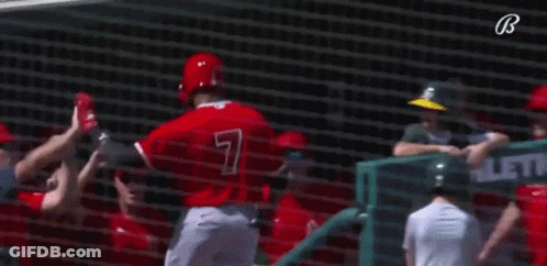 A Group Of Baseball Players Are Giving Each Other A High Five While Standing In Front Of A Net . GIF