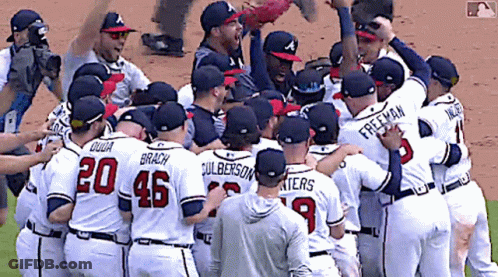 A Group Of Baseball Players Are Huddled Together And One Of Them Has The Number 20 On His Jersey GIF